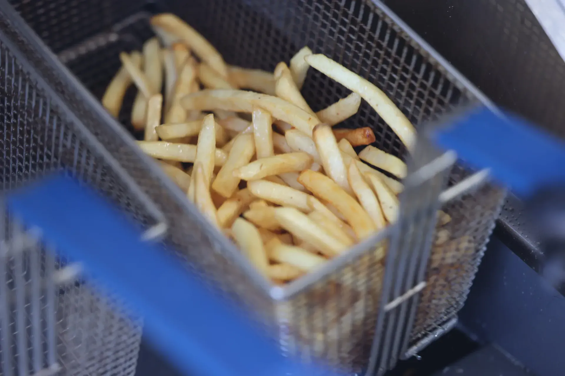 Golden hand-cut fries piled in the fryer basket