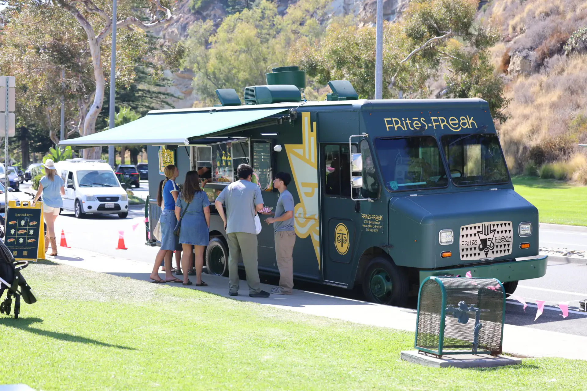 The FRitēS-FReaK truck parked with its awning out and a line of customers